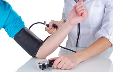 In this picture, a doctor is checking a patient's blood pressure using a blood pressure monitoring machine.
