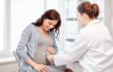 A picture of a doctor checking a pregnant woman